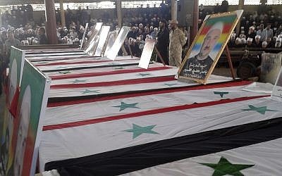 In this photo released by the Syrian official news agency SANA, mourners from the Druze community attend a mass funeral of people killed a day earlier by a series of suicide bombings launched by the Islamic State's fighters on the eastern and northern countryside of the southern province of al-Sweida, Syria, on July 26, 2018. (SANA via AP)