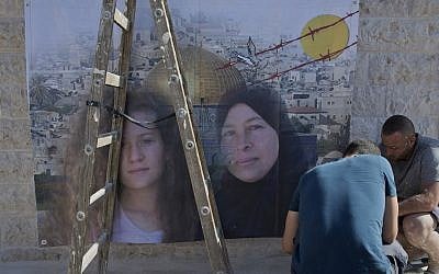 Palestinians hang a poster showing Nariman Tamimi, right, and her daughter Ahed, during preparations for their upcoming release from an Israeli prison after serving an eight month sentence, at the family house in the West Bank village of Nebi Saleh, west of Ramallah, July 28, 2018. (AP Photo/Nasser Nasser)