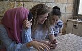 Ahed Tamimi, center, surfs the internet with her friends at the family house in the West Bank village of Nebi Saleh, near Ramallah, Monday, July 30, 2018. (AP Photo/Nasser Nasser)