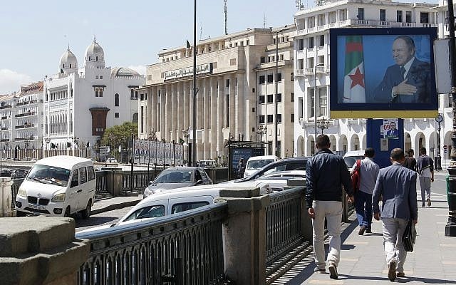 Illustrative: Algerians walk past a portrait of Algerian President Abdelaziz Bouteflika in the capital Algiers on May 2, 2017. (AP Photo/Toufik Doudou) Illustrative: Algerians walk past a portrait of Algerian President Abdelaziz Bouteflika in the capital Algiers on May 2, 2017. (AP Photo/Toufik Doudou)