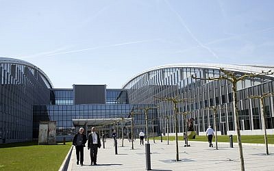 People walk outside the entrance of the new NATO headquarters in Brussels on April 19, 2018 (AP Photo/Virginia Mayo)