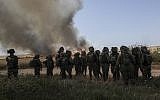 Illustrative: Israeli soldiers watch a wheat field that caught fire next to kibbutz Nahal Oz along the Israel-Gaza border, May 14, 2018 (AP Photo/Tsafrir Abayov)
