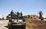 Syrian soldiers flashing the victory sign as they sit on their military vehicle at Naseeb border crossing with Jordan, in the southern province of Daraa, Syria, July 7, 2018. (SANA via AP)