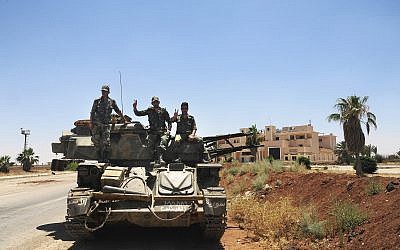 Syrian soldiers flashing the victory sign as they sit on their military vehicle at Naseeb border crossing with Jordan, in the southern province of Daraa, Syria, July 7, 2018. (SANA via AP)