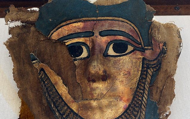 A recently discovered gilded mummy mask is displayed after it was found in a disturbed context of the hall way of a burial chamber dating back some 2,500 years at an ancient necropolis near Egypt's famed pyramids in Saqqara, Giza, Saturday, July 14, 2018. (AP/Amr Nabil)