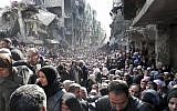 In this January 31, 2014 file photo released by UNRWA, shows residents of the besieged Palestinian camp of Yarmouk, lining up to receive food supplies, in Damascus, Syria. (UNRWA via AP, File)