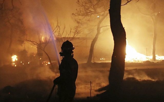 A firefighter sprays water on the fire in the town of Mati, east of Athens, July 23, 2018. (AP Photo/Thanassis Stavrakis) A firefighter sprays water on the fire in the town of Mati, east of Athens, July 23, 2018. (AP Photo/Thanassis Stavrakis)