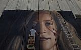 An artist paints a giant mural of prominent Palestinian activist Ahed Tamimi on part of the Israeli security barrier, in the West Bank city of Bethlehem on July 25, 2018. (AP Photo/Nasser Nasser)