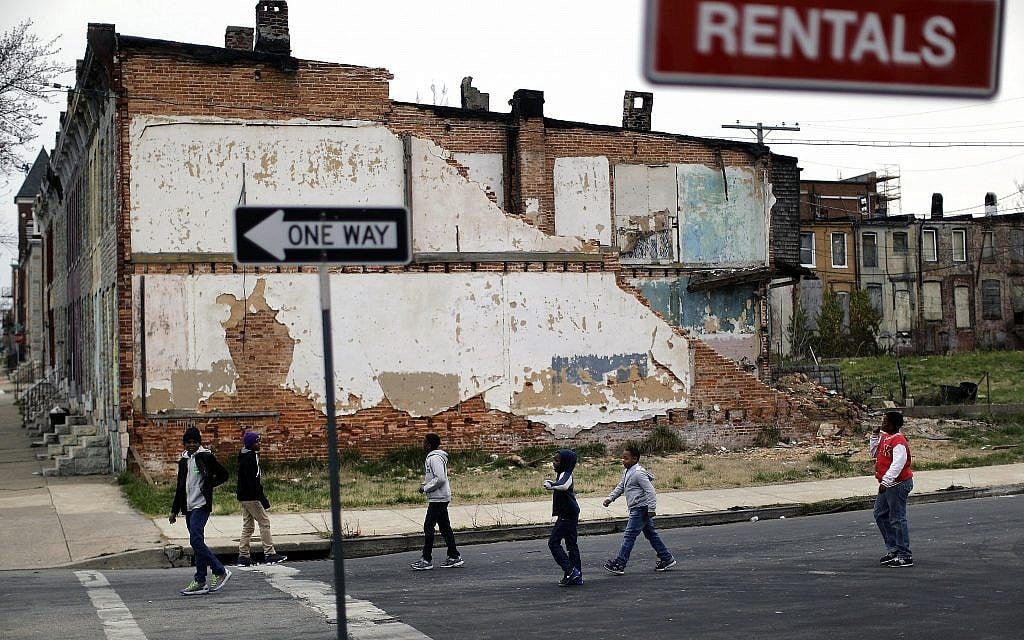 In this April 4, 2013 file photo, a group of boys walk past a partially collapsed row house in Baltimore. (AP/Patrick Semansky) In this April 4, 2013 file photo, a group of boys walk past a partially collapsed row house in Baltimore. (AP/Patrick Semansky)