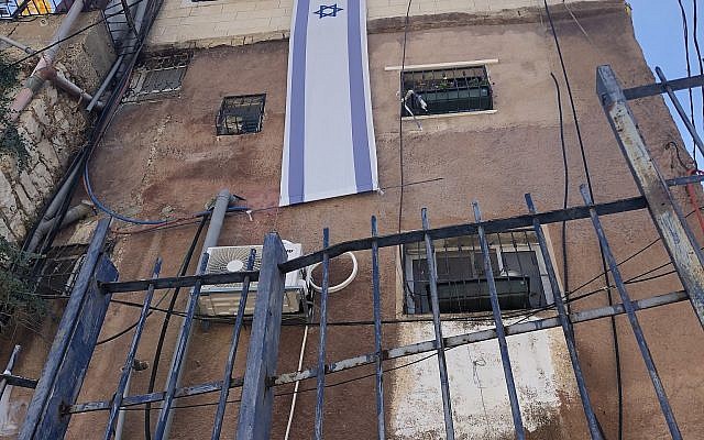 The Israeli flag is mounted on a building owned by Ateret Cohanim in the Batan al-Hawa neigbhorhood of Silwan, East Jerusalem, July 31, 2018. (Sue Surkes) The Israeli flag is mounted on a building owned by Ateret Cohanim in the Batan al-Hawa neigbhorhood of Silwan, East Jerusalem, July 31, 2018. (Sue Surkes)