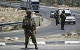 Illustrative: Israeli soldiers block the entrance to the industrial zone of the southern West Bank city of Hebron, on June 15, 2014. (Hadas Parush/Flash90/File)