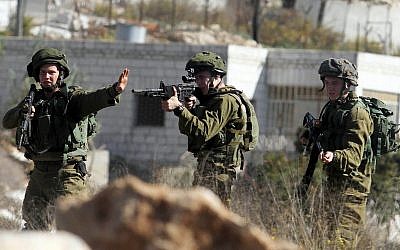 Illustrative: IDF soldiers near the entrance to the West Bank settlement of Beit El, October 24, 2014. (STR/Flash90)