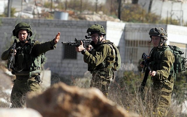 Illustrative: IDF soldiers near the entrance to the West Bank settlement of Beit El, October 24, 2014. (STR/Flash90)