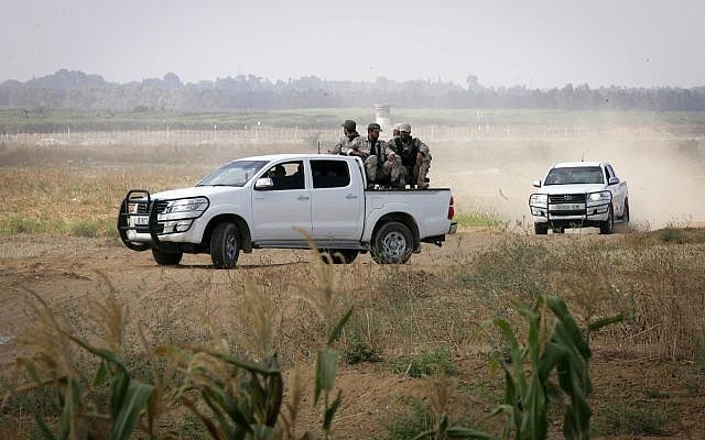Illustrative: Members of the Hamas terror group's armed wing sit in the back of a pick-up truck watching Israeli bulldozers working along a barbed wire fence that separates Khan Younis in the southern Gaza Strip from Israel, on June 10, 2015. (Abed Rahim Khatib /Flash90) Illustrative: Members of the Hamas terror group's armed wing sit in the back of a pick-up truck watching Israeli bulldozers working along a barbed wire fence that separates Khan Younis in the southern Gaza Strip from Israel, on June 10, 2015. (Abed Rahim Khatib /Flash90)