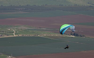Illustrative: A paraglider flies over northern Israel on February 18, 2017. (Nati Shohat/Flash90)