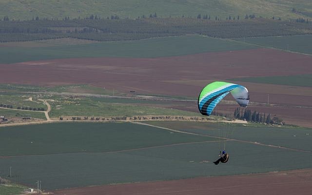 Illustrative: A paraglider flies over northern Israel on February 18, 2017. (Nati Shohat/Flash90)