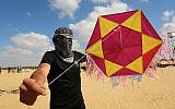 A Palestinian protester displays a kite loaded with an incendiary device before launching it towards Israel, east of Rafah in the southern Gaza Strip, on June 29, 2018 (Abed Rahim Khatib/Flash90)