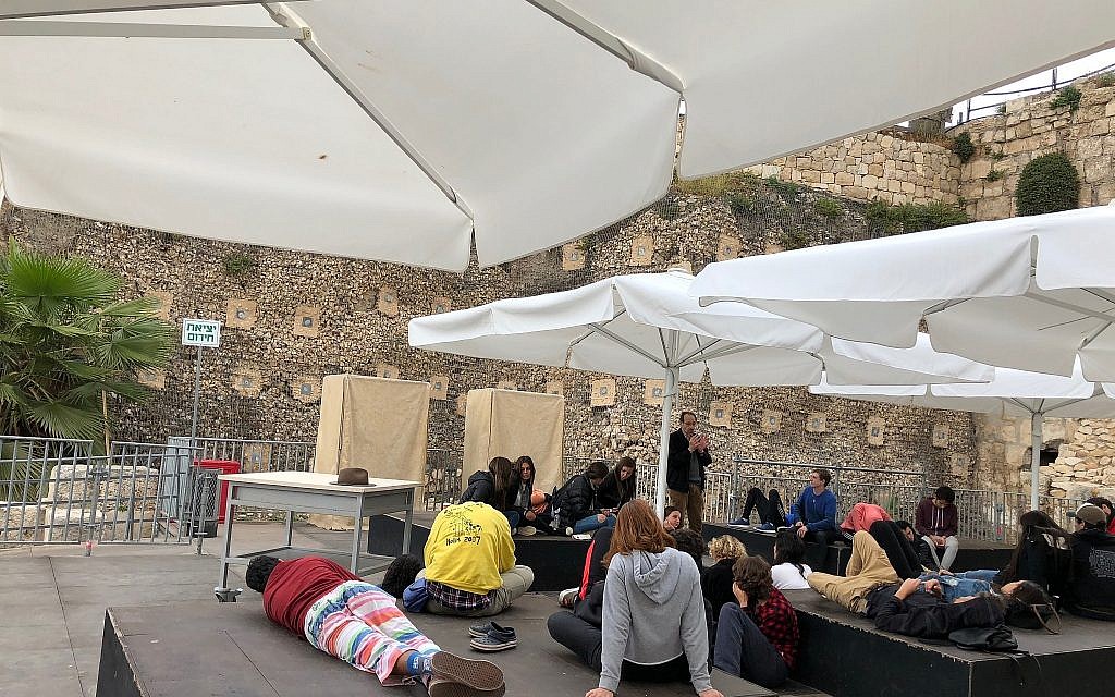 A Spanish-speaking teen tour rests on the Robinson's Arch prayer platform, April 2018. (Amanda Borschel-Dan/ToI)