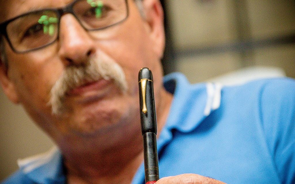 Yaron Roksa holds pen confiscated by the Nazis from his father at Neuengamme concentration camp in 1944. The pen was returned to the Roksa family by ITS on July 3, 2018. (Laura Ben-David/Courtesy of ITS)