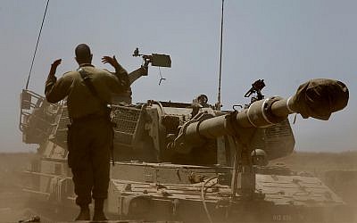 An Israeli soldier guides a mobile artillery piece near the border with Syria in the Golan Heights, July 25, 2018. (AP/Ariel Schalit)
