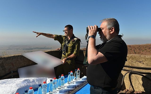 Defense Minister Avigdor Liberman peers through binoculars on a hilltop overlooking the border with Syria as Brig. Gen. Amit Fisher gives him a briefing on developments in the area, on July 10, 2018. (Ariel Hermoni/Defense Ministry) Defense Minister Avigdor Liberman peers through binoculars on a hilltop overlooking the border with Syria as Brig. Gen. Amit Fisher gives him a briefing on developments in the area, on July 10, 2018. (Ariel Hermoni/Defense Ministry)