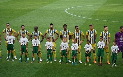 Hungarian children standing with Maccabi TLV players in tribute to Holocaust hero István Tóth at Groupama Arena in Budapest, July 12 2018. (Courtesy/ World Jewish Congress)