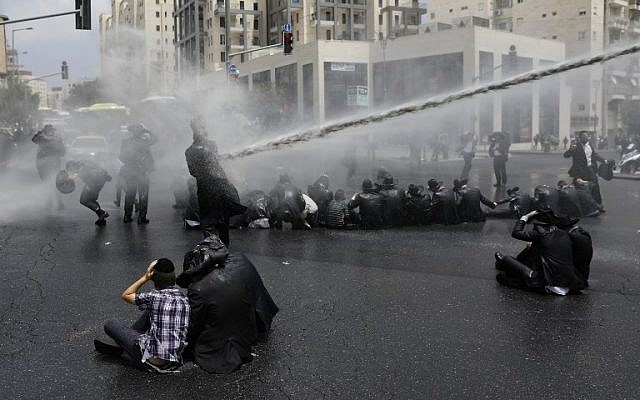 Ultra-Orthodox Jews, demonstrating at the arrest of a draft dodger, are sprayed with water cannons by Israeli security forces in Jerusalem on August 2, 2018. (AFP PHOTO / MENAHEM KAHANA)