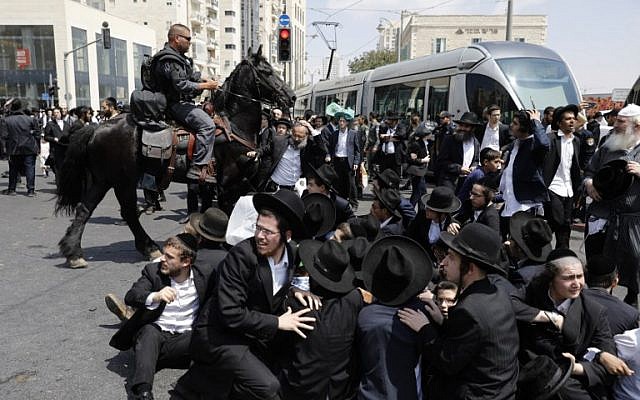 A member of the Israeli mounted police unit tries to disperse a demonstration of ultra-Orthodox men protesting against the arrest of a draft dodger in Jerusalem on August 2, 2018. (AFP Photo/Menahem Kahana) A member of the Israeli mounted police unit tries to disperse a demonstration of ultra-Orthodox men protesting against the arrest of a draft dodger in Jerusalem on August 2, 2018. (AFP Photo/Menahem Kahana)