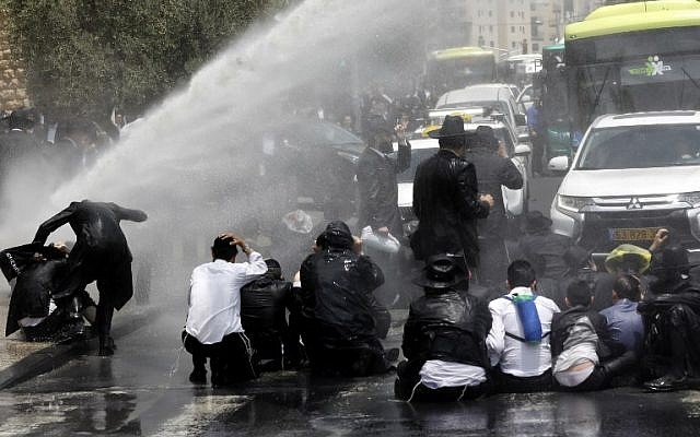 Ultra-Orthodox Jewish men are sprayed with water cannons by Israeli security forces protesting against the arrest of a draft dodger in Jerusalem on August 2, 2018. (AFP PHOTO / Menahem KAHANA) Ultra-Orthodox Jewish men are sprayed with water cannons by Israeli security forces protesting against the arrest of a draft dodger in Jerusalem on August 2, 2018. (AFP PHOTO / Menahem KAHANA)