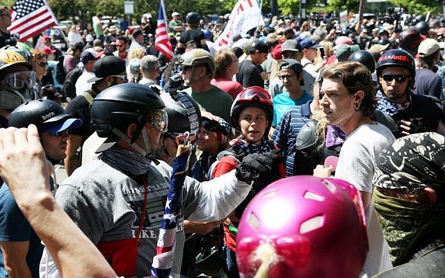 An alt-right sympathizer, left, knocks the hat off an opponent's head as alt-right activists, anti-fascist protesters, and people on all sides of the political spectrum gather for a campaign rally organized by right-wing organizer, Patriot Prayer founder and Republican Senate candidate Joey Gibson in Portland, Oregon, August 4, 2018.
(AFP/Thomas Patterson) An alt-right sympathizer, left, knocks the hat off an opponent's head as alt-right activists, anti-fascist protesters, and people on all sides of the political spectrum gather for a campaign rally organized by right-wing organizer, Patriot Prayer founder and Republican Senate candidate Joey Gibson in Portland, Oregon, August 4, 2018.
(AFP/Thomas Patterson)