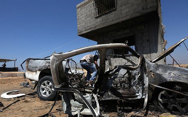 A Palestinian man inspects a damaged car after an Israeli airstrike on Beit Lahya, northern gaza strip, on August 5, 2018. (AFP/ MAHMUD HAMS) A Palestinian man inspects a damaged car after an Israeli airstrike on Beit Lahya, northern gaza strip, on August 5, 2018. (AFP/ MAHMUD HAMS)