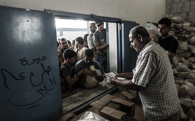 Palestinians receive aid at a United Nations food distribution center in the Jabaliya refugee camp in the northern Gaza Strip on August 8, 2018. (AFP Photo/Mahmud Hams) Palestinians receive aid at a United Nations food distribution center in the Jabaliya refugee camp in the northern Gaza Strip on August 8, 2018. (AFP Photo/Mahmud Hams)