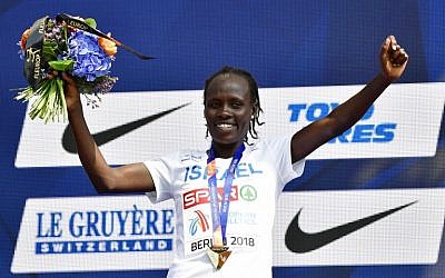 Winner Israel's Lonah Chemtai Salpeter celebrates on the podium with her medal during the medal ceremony of the women's 10000m event during the European Athletics Championships in Berlin on August 9, 2018. (AFP PHOTO / Tobias SCHWARZ)
