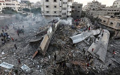 A picture taken on August 9, 2018, shows people inspecting the rubble of a building targeted by the Israeli Air Force in response to a rocket attack that hit southern Israel earlier in the day on August 9, 2018. (AFP Photo/Mahmud Hams)