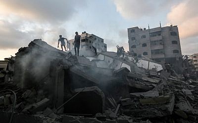 A picture taken on August 9, 2018, shows people inspecting the rubble of a building targeted by the Israeli Air Force in response to a rocket attack that hit southern Israel earlier in the day on August 9, 2018. (AFP Photo/Mahmud Hams)