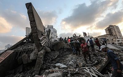 A picture taken on August 9, 2018 shows people inspecting the rubble of a cultural center following an Israeli air strike on Gaza City. (AFP PHOTO / MAHMUD HAMS)