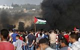 Palestinian protesters wave their flag as they gather during a demonstration at the Israel-Gaza border, in Khan Younis in the southern Gaza Strip on August 10, 2018. (AFP PHOTO / Said KHATIB)