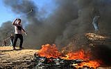 A Palestinian uses a slingshot during clashes along the border between Israel and the Gaza Strip, in the southern Gaza city of Khan Younis, on August 10, 2018. (AFP Photo/Said Khatib)