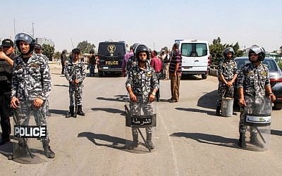 Members of the Egyptian security forces form a perimeter for investigators gathered around the body of a suicide bomber, whose explosives detonated before reaching the Coptic Orthodox Church of the Virgin Mary, on the northern outskirts of the capital Cairo, on August 11, 2018. (AFP PHOTO / STRINGER)