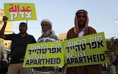 Arab Israelis carry banners during a demonstration to protest against the nation-state law in Tel Aviv on August 11, 2018. (AFP/ Ahmad GHARABLI)