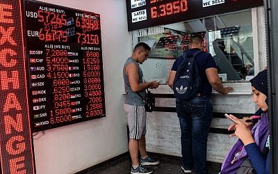 People check currency exchange rates at a currency exchange office on August 11, 2018 in Istanbul. (AFP/ Yasin AKGUL)