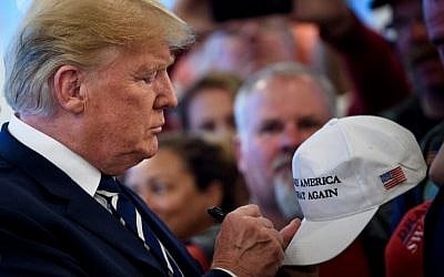 US President Donald Trump signs a hat while meeting with supporters during a Bikers for Trump event at the Trump National Golf Club in Bedminster, New Jersey on August 11, 2018. (AFP/Brendan Smialowski)