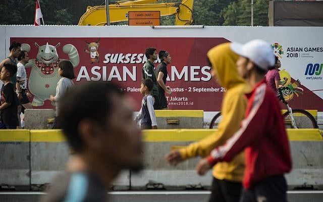 People exercise next to a banner for the 2018 Asian Games during a car-free day in Jakarta on August 12, 2018. (AFP PHOTO / BAY ISMOYO) People exercise next to a banner for the 2018 Asian Games during a car-free day in Jakarta on August 12, 2018. (AFP PHOTO / BAY ISMOYO)