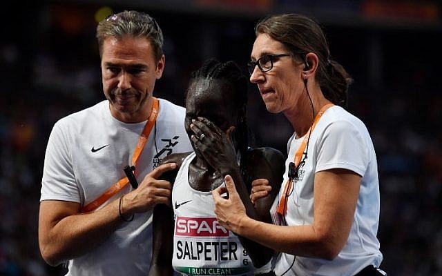 Runner Lonah Chemtai Salpeter is consoled after she miscounted the laps and stopped running too early in the women's 5000m final race during the European Athletics Championships at the Olympic stadium in Berlin, on August 12, 2018. (John MacDougall/AFP) Runner Lonah Chemtai Salpeter is consoled after she miscounted the laps and stopped running too early in the women's 5000m final race during the European Athletics Championships at the Olympic stadium in Berlin, on August 12, 2018. (John MacDougall/AFP)
