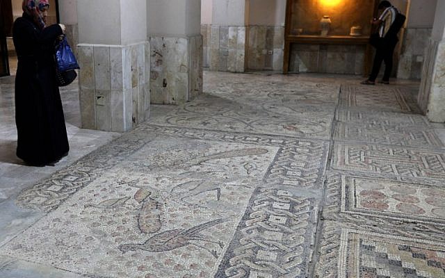 A Syrian woman takes pictures of mosaic on the floor of the Idlib Museum after it reopened on August 13, 2018 in the northern Syrian city of Idlib. (AFP PHOTO / OMAR HAJ KADOUR) A Syrian woman takes pictures of mosaic on the floor of the Idlib Museum after it reopened on August 13, 2018 in the northern Syrian city of Idlib. (AFP PHOTO / OMAR HAJ KADOUR)