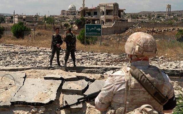 A member of the Russian military police and Syrian government forces patrol near the village al-Hamidia in the Syrian Golan Heights on August 14, 2018. (AFP/Andrey Borodulin) A member of the Russian military police and Syrian government forces patrol near the village al-Hamidia in the Syrian Golan Heights on August 14, 2018. (AFP/Andrey Borodulin)