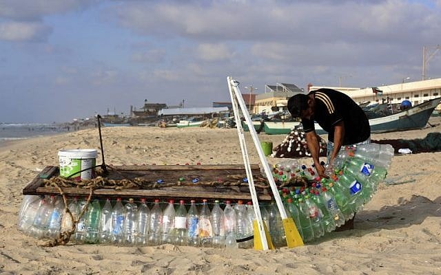 Palestinian fisherman Mouad Abu Zeid repairs his boat that he made of 700 Plastic empty bottles on a beach in Rafah in the southern Gaza Strip on August 14, 2018.(AFP PHOTO / SAID KHATIB) Palestinian fisherman Mouad Abu Zeid repairs his boat that he made of 700 Plastic empty bottles on a beach in Rafah in the southern Gaza Strip on August 14, 2018.(AFP PHOTO / SAID KHATIB)