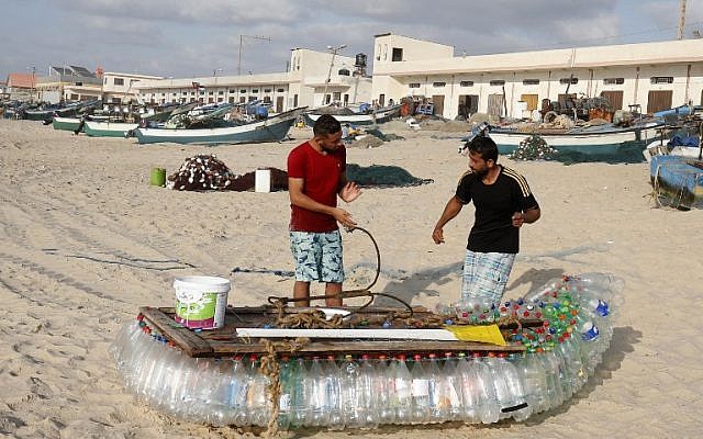 Palestinian fisherman Mouad Abu Zeid (R) and his friend work on his boat that he made of 700 Plastic empty bottles on a beach in Rafah in the southern Gaza Strip on August 14, 2018. (AFP PHOTO / SAID KHATIB) Palestinian fisherman Mouad Abu Zeid (R) and his friend work on his boat that he made of 700 Plastic empty bottles on a beach in Rafah in the southern Gaza Strip on August 14, 2018. (AFP PHOTO / SAID KHATIB)