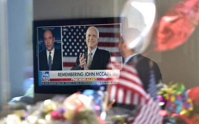 A man in the lobby of Senator John McCain's former office building watches a Fox News report as flowers and balloons from a makeshift memorial located outside the building are reflected in the building's glass window, August 27, 2018 in Phoenix, Arizona. (AFP PHOTO / Robyn Beck) A man in the lobby of Senator John McCain's former office building watches a Fox News report as flowers and balloons from a makeshift memorial located outside the building are reflected in the building's glass window, August 27, 2018 in Phoenix, Arizona. (AFP PHOTO / Robyn Beck)