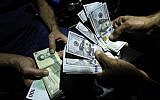In this photo from August 8, 2018, a man exchanges Iranian rials for US dollars at an exchange shop in the Iranian capital Tehran. (AFP Photo/Atta Kenare)